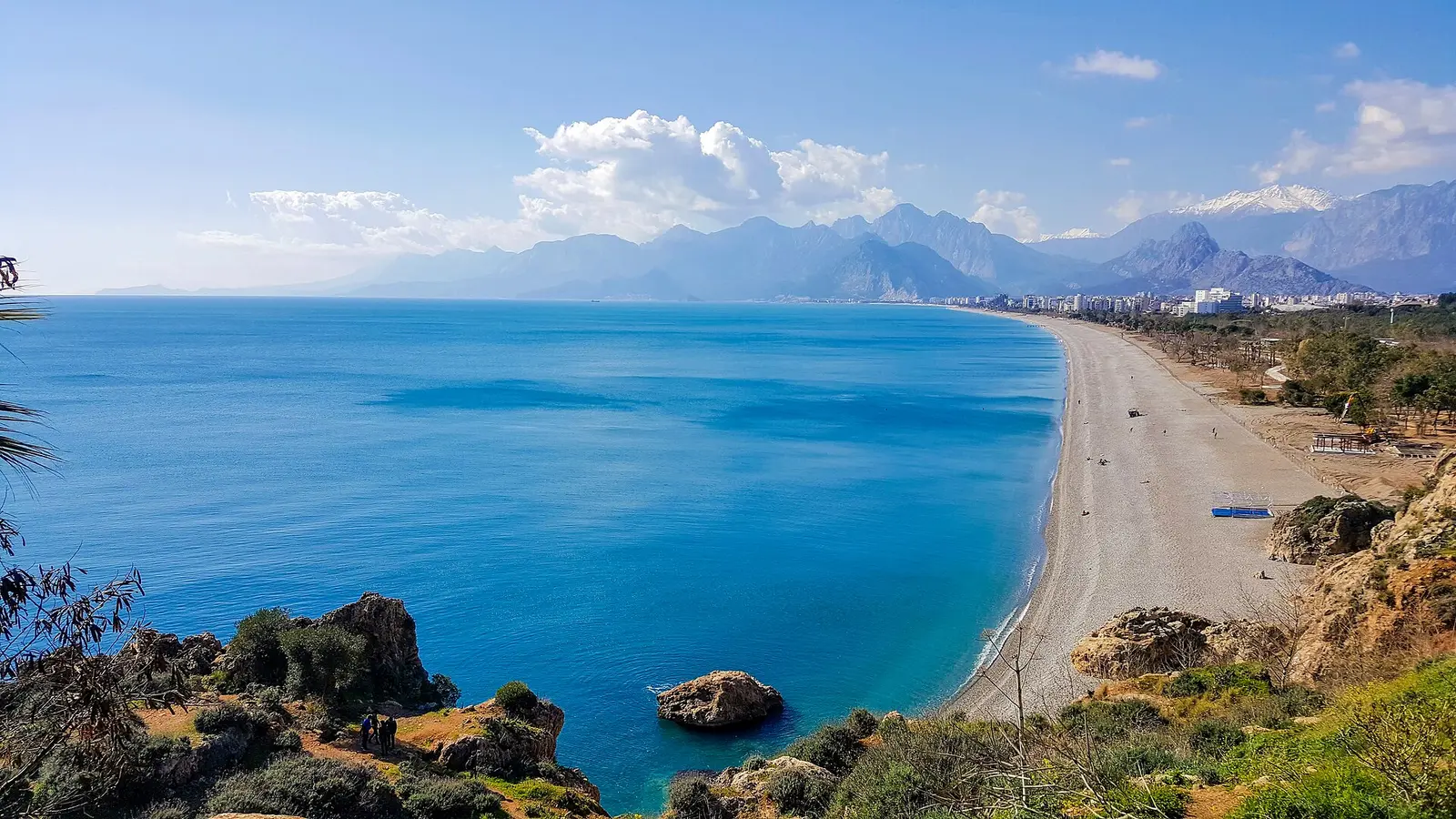 View from the Antalya cliffs along Konyaaltı Beach with turquoise sea and the Taurus mountains beyond
