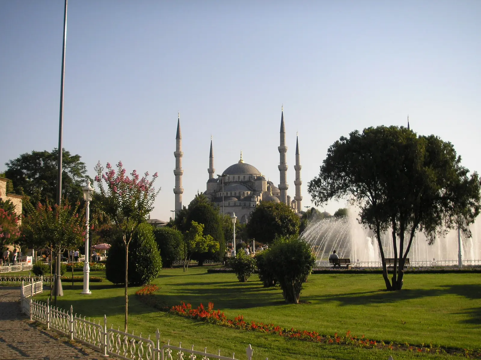 Sultanahmet Blue Mosque seen across a park with a fountain and trees in Istanbul