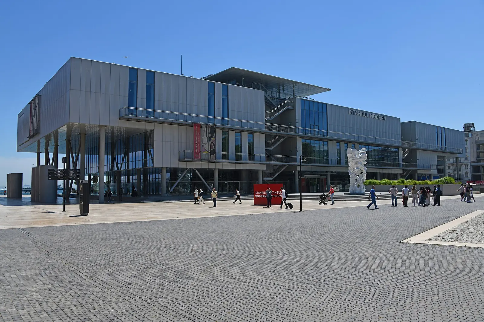 Istanbul Modern museum, a grey metal-clad building on the Karaköy waterfront, seen from the quayside on a sunny day