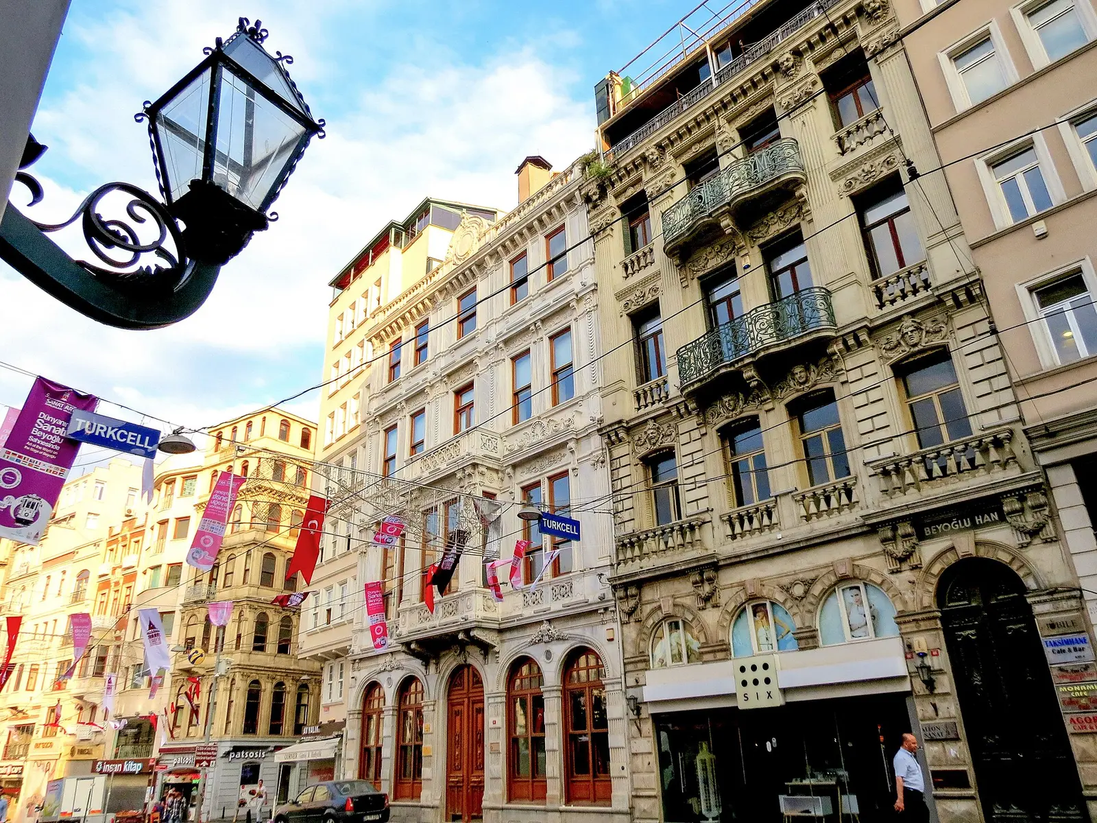 Ornate 19th-century buildings along Istiklal Avenue in Beyoğlu, Istanbul, with lamp posts and flags